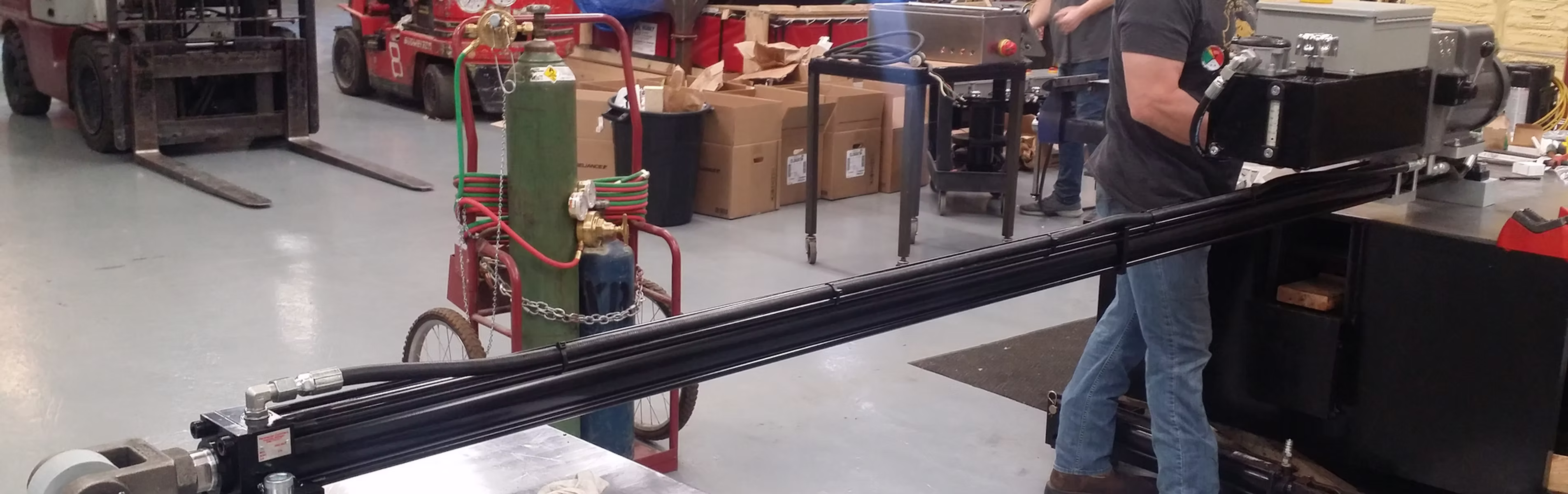 Industrial workspace with welding gas tanks, machinery, and forklift