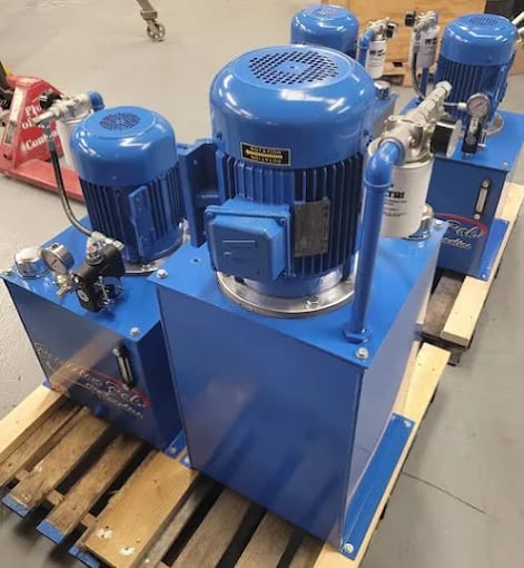 Blue industrial hydraulic power units with electric motors on wooden pallets